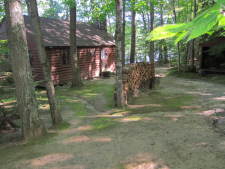 Lake House Secluded, Lakeside, Split-log Cottage With Fireplace, Rowboat, Cottage and firewood shed viewed from parking area., on Lake Horace in New Hampshire - Lakehouse Vacation Rental - Lake Home for rent on LakeHouseVacations.com