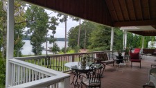 Lake House Sandy Beach And Deep Water Dock, Covered deck extends full length of house on the lakeside (sunset), looking north, up the lake., on Lake Oconee in Georgia - Lakehouse Vacation Rental - Lake Home for rent on LakeHouseVacations.com